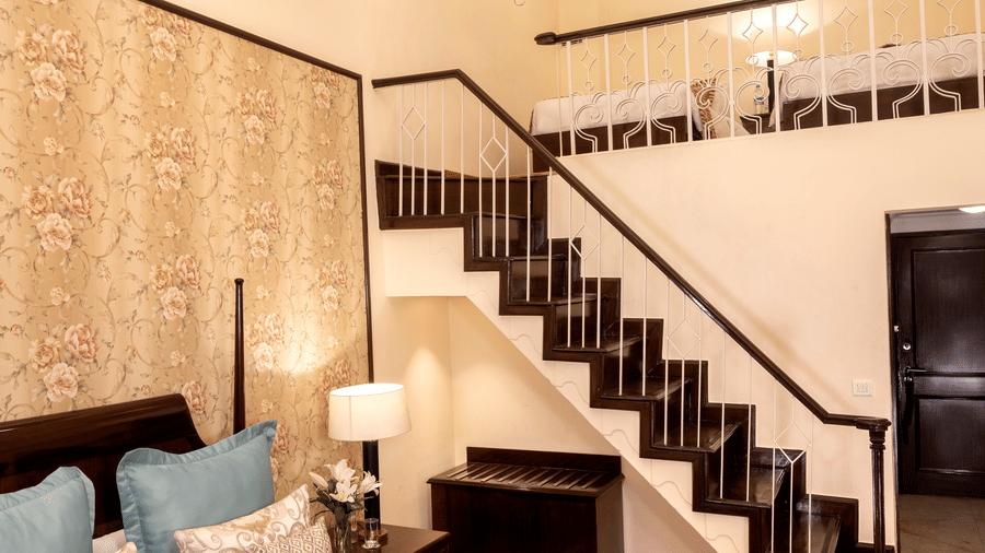a brightly lit image of the Duplex Family Suite with a staircase leading to the upper floor at The Claridges Nabha Residence