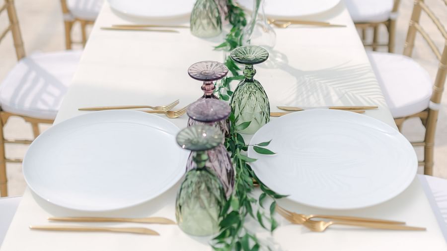 a table with cutlery and plants kept on it during an event