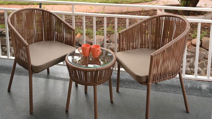 Two chairs on a patio with a garden view outside the Deluxe Cottage at Mango Leaf Lake Resort, Pune