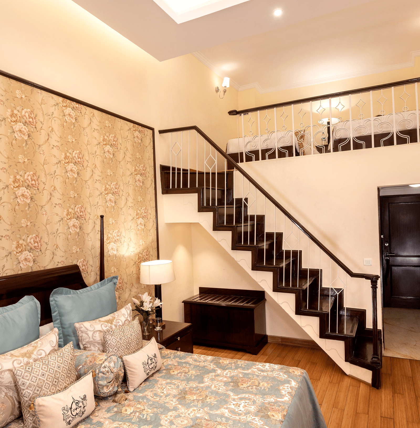 a brightly lit image of the Duplex Family Suite with a staircase leading to the upper floor at The Claridges Nabha Residence