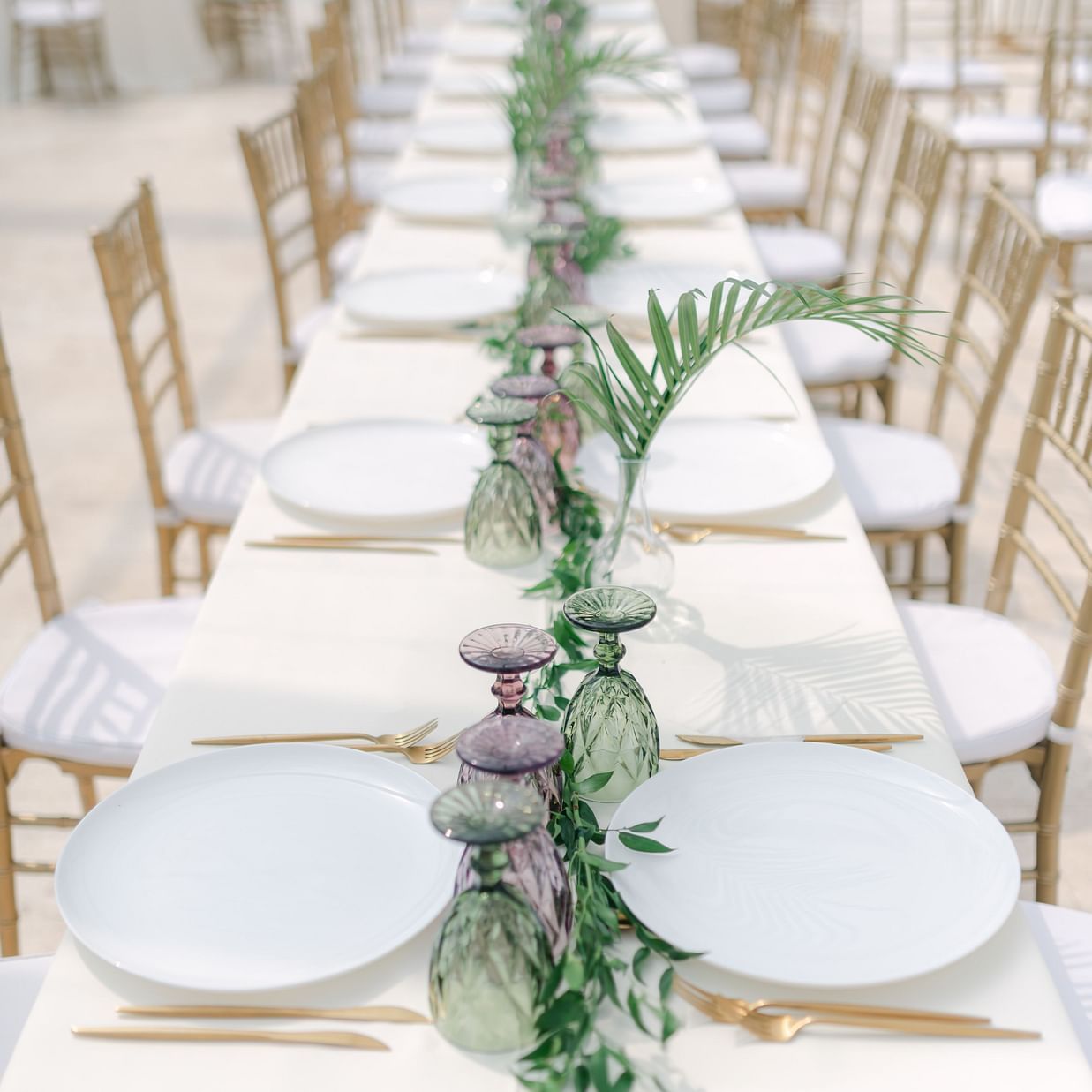 a table with cutlery and plants kept on it during an event