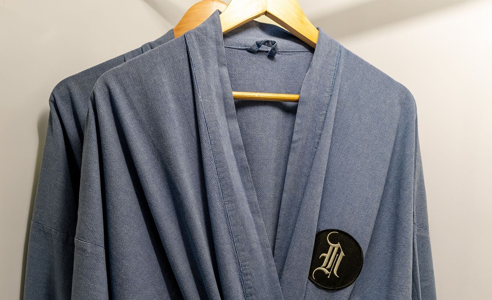 A close up shot of grey bathrobes hung in the wardrobe - Night Hotel Bangkok.