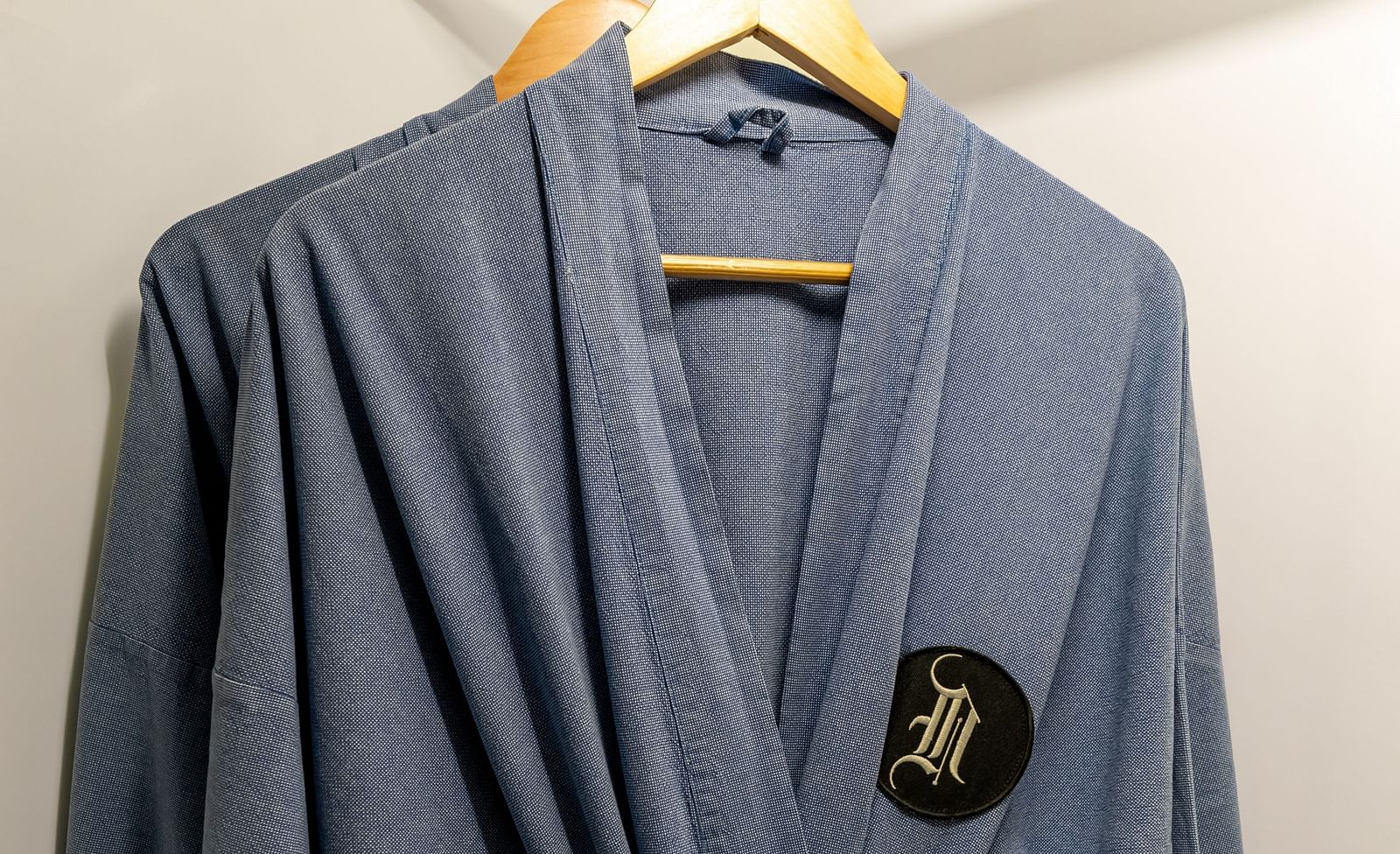 A close up shot of grey bathrobes hung in the wardrobe - Night Hotel Bangkok.