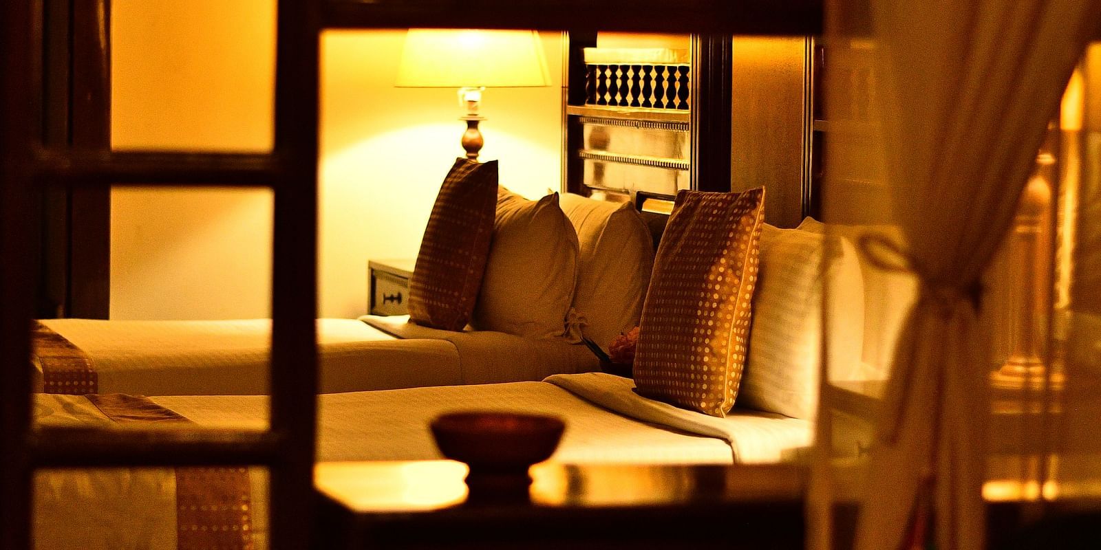 An image of a corridor with wooden benches on one side and wooden wall on the other - Hoysala Village Resort, Hassan