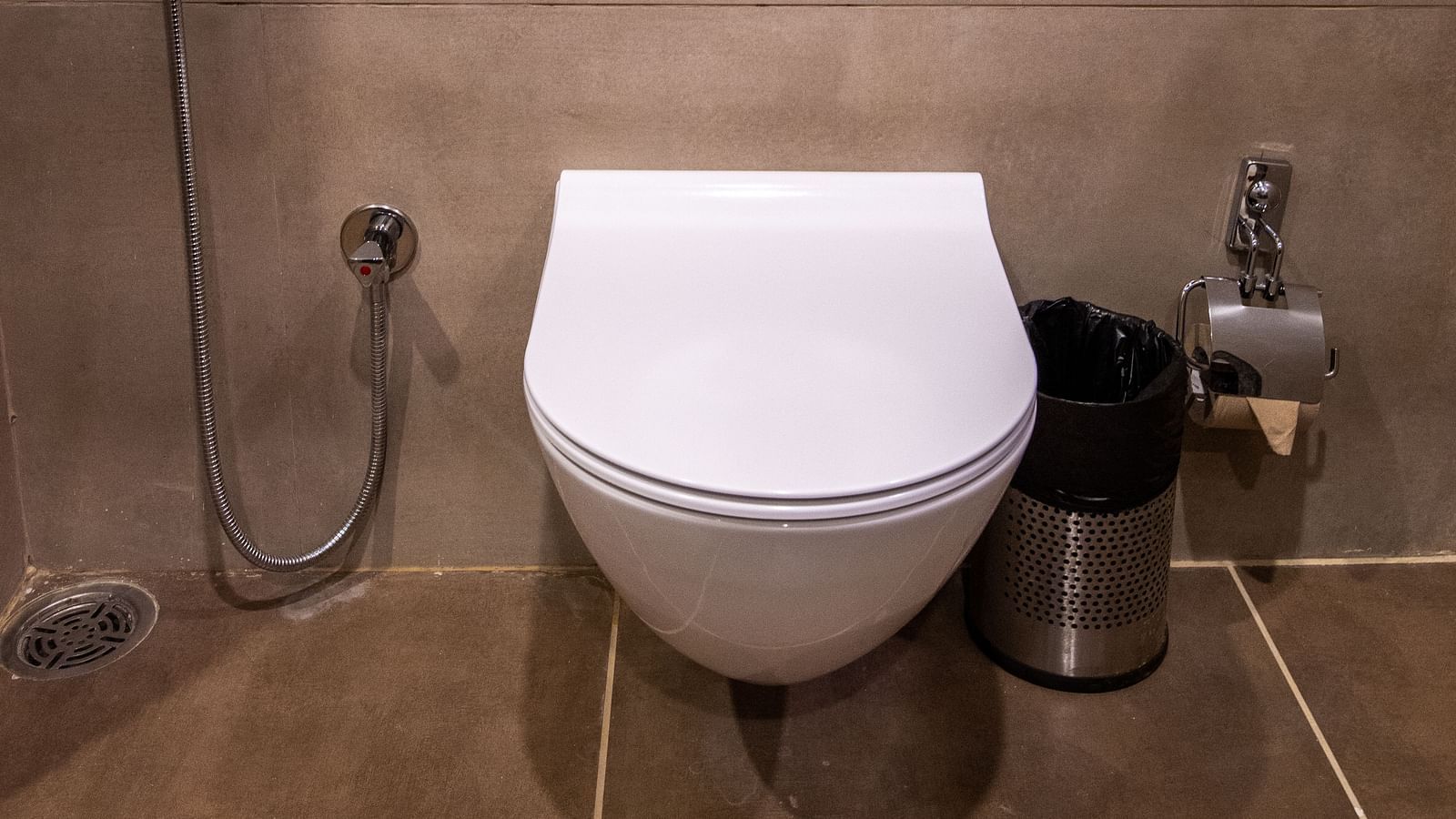 An image of a commode in a modern washroom with a tiled flooring - Rajbagh Wellness, Udaipur