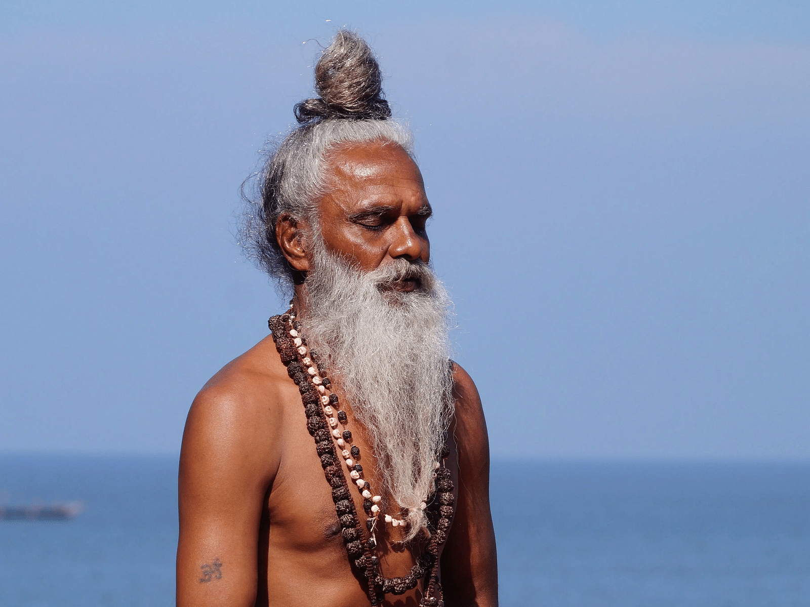 A man wearing saffron dhoti and meditating