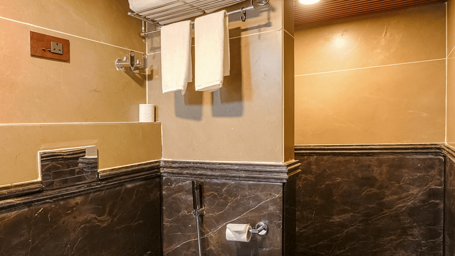 The claasic room bathroom at BluSalzz Terrah Hills Resort, Dalhousie, featuring  a toilet, towels, and toileteries.