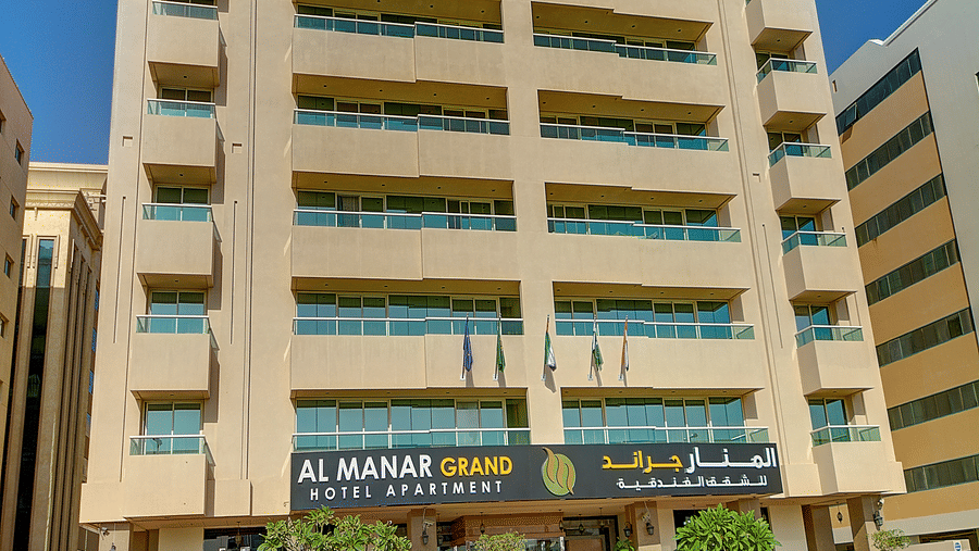 A vertical shot of the hotel building exterior, highlighting its balconies and the street-level entrance area - Al Manar Grand Hotel Apartment, Bur Dubai