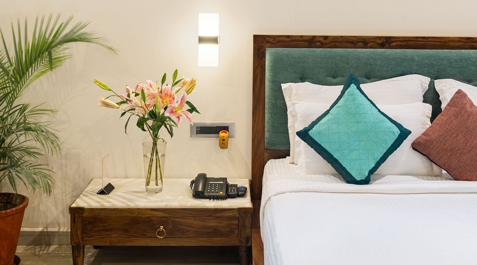 image of the king size bed along with the bed side table with a beautiful lamp at the luxury pond view villa at aranya vilas