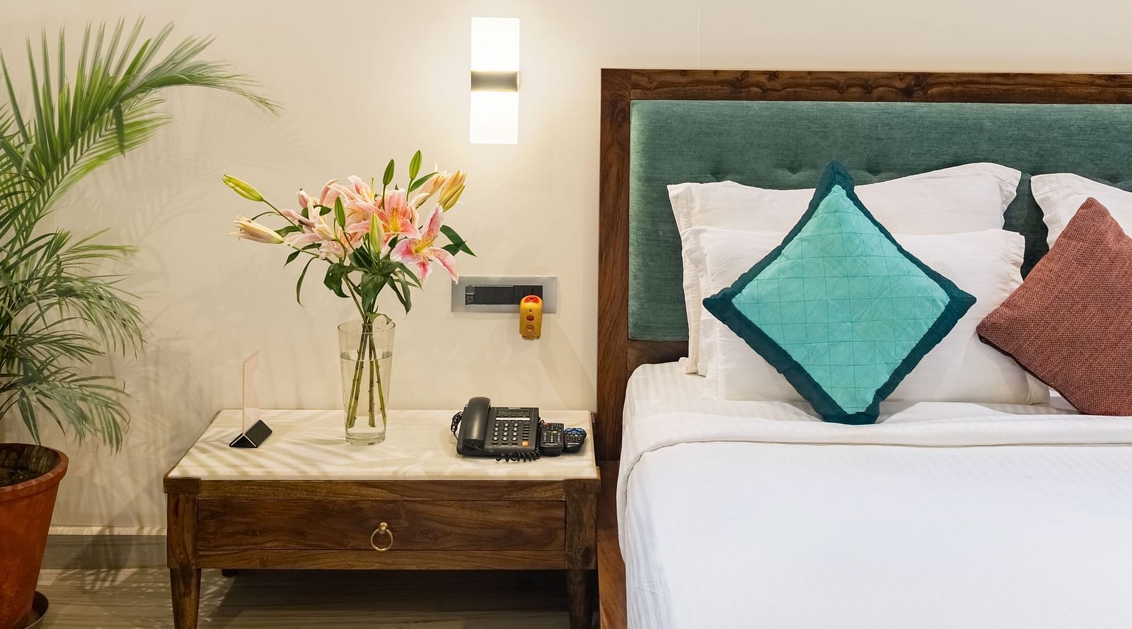 Side image of the luxury villa featuring a king size bed with a bed side table along with a bed side lamp