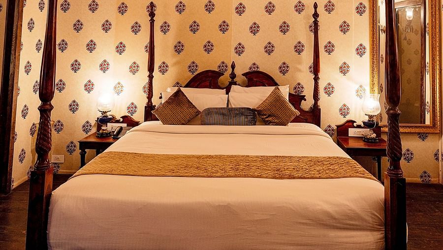 Image of a luxury tent with a bed and a chandelier above the bed Rajasthali Resort & Spa Jaipur.