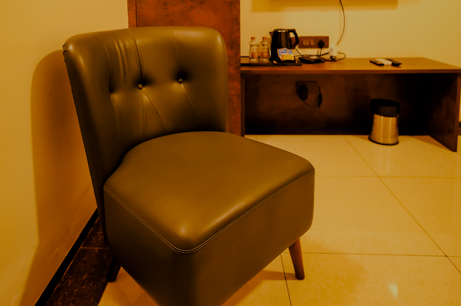A comfortable chair in a room along with the flat screen TV at Nirantara Resort & Spa