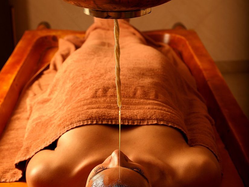 masseur performing shiro abhyangam on a guest at aruna spa in manesar