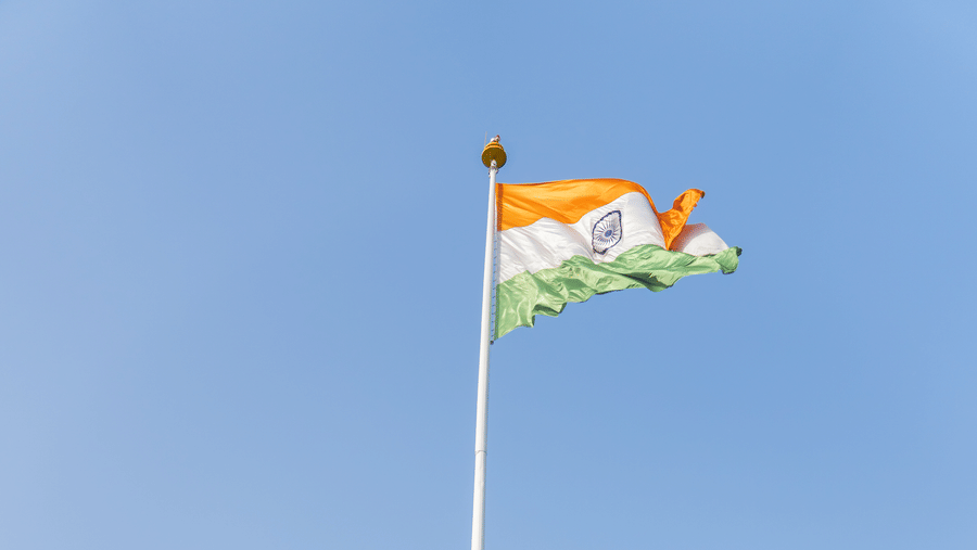 A group of people standing in front of the Indian flag - Karma Lakelands.