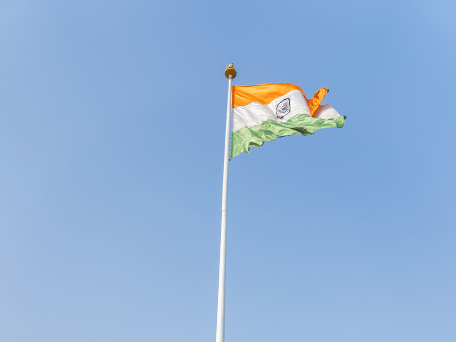 A group of people standing in front of the Indian flag - Karma Lakelands.