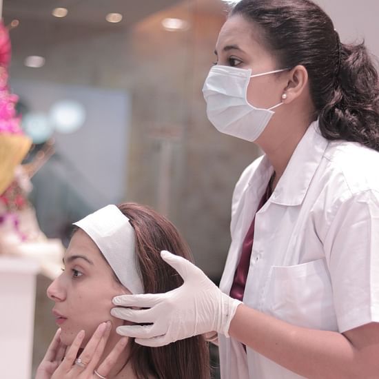 A lady doing face massage to a person