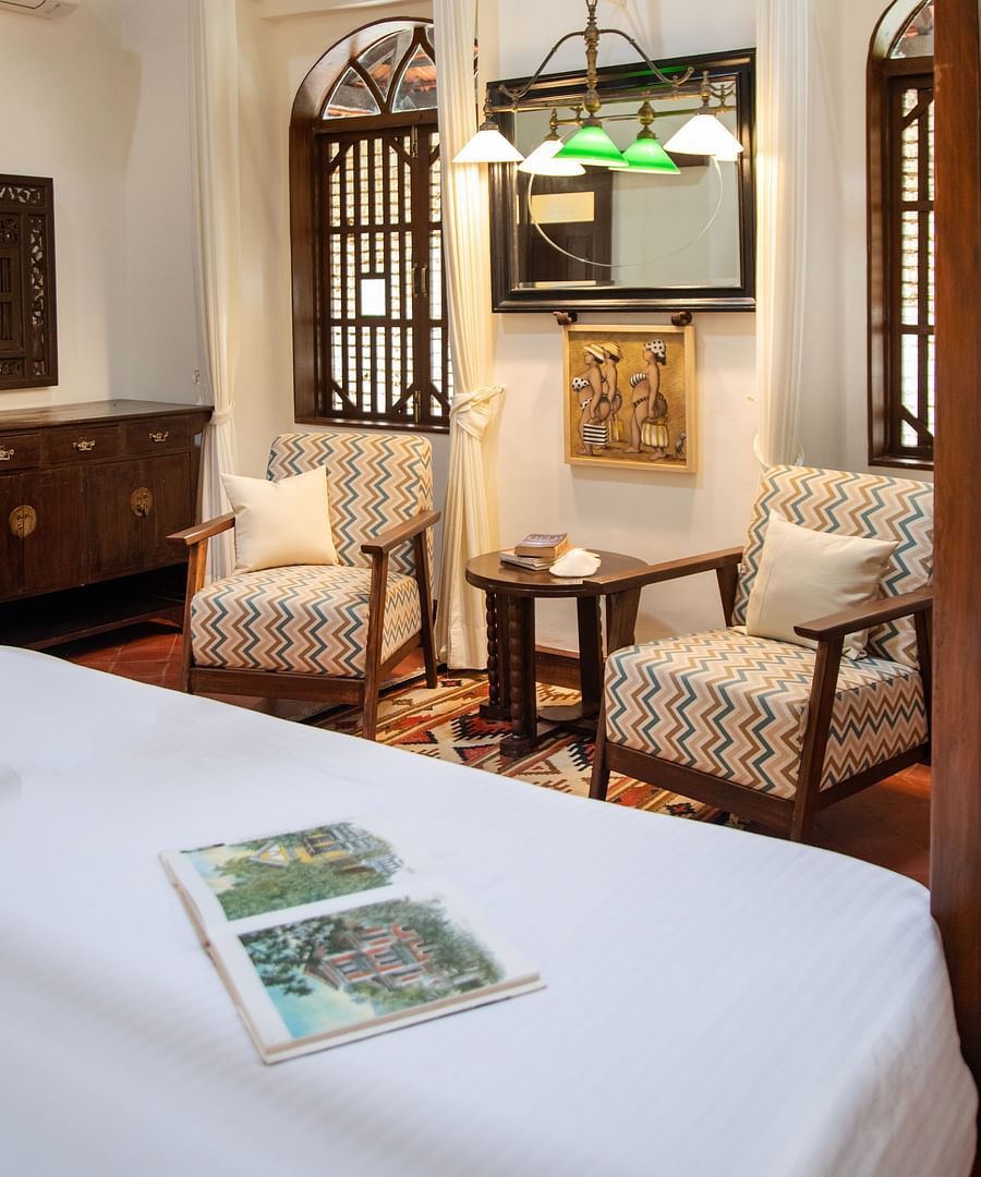 An image of a beautiful white sofas and white bed with big windows at Lamrin Ucassaim Hotel, Goa