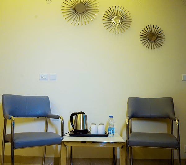 Seating corner with two chairs and a tea tray with an electric kettle.