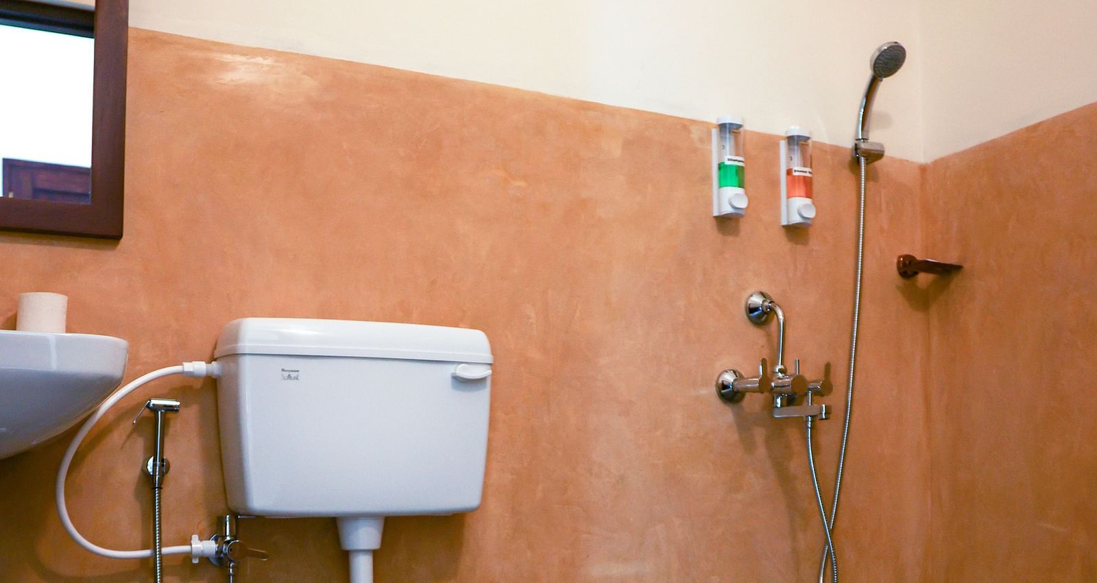 A western bathroom that has a commode, a sink, mirror on the wall, faucet, showerhead, etc | Mango Hill La Serene, Pondicherry