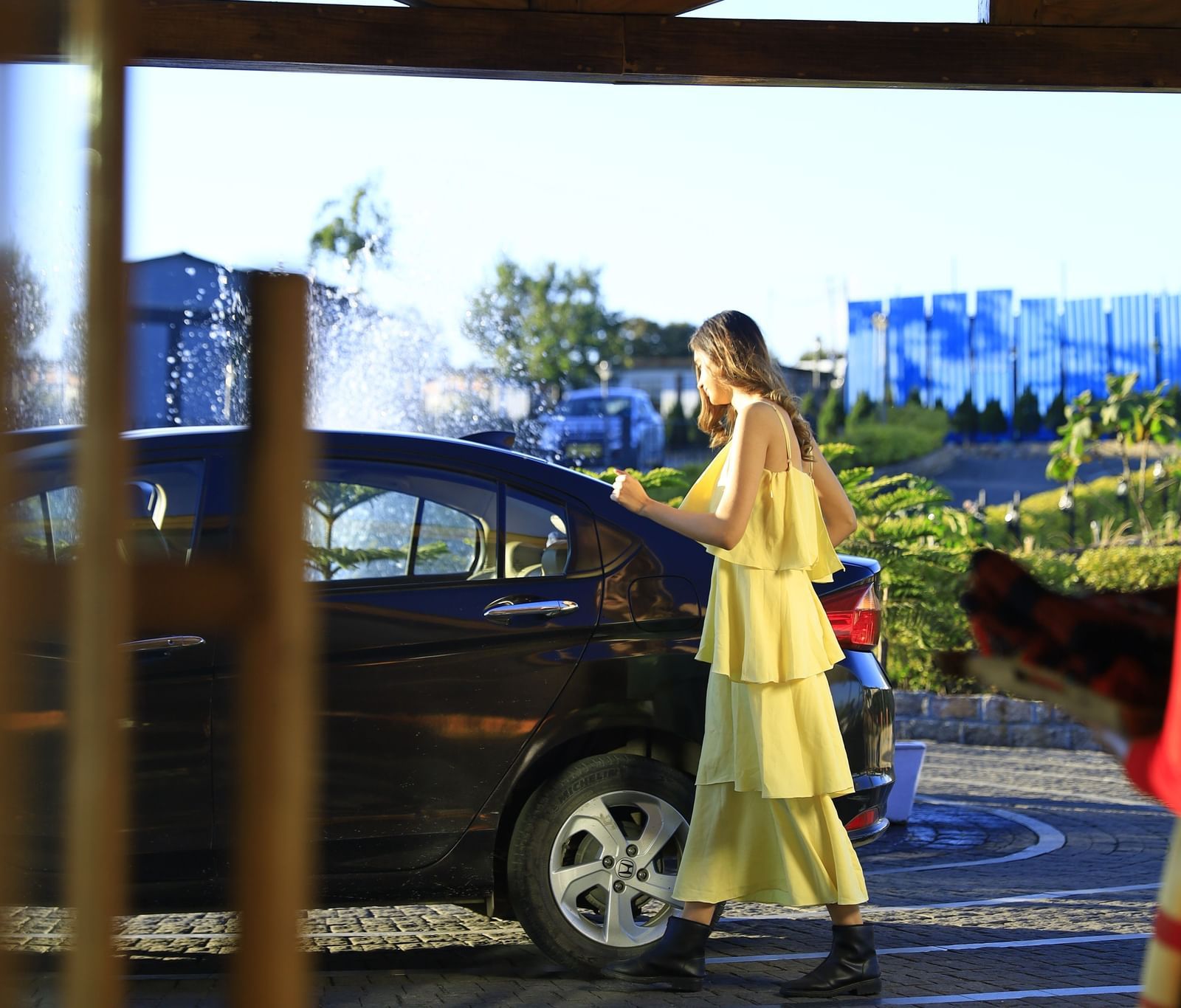A woman wearing a yellow dress boarding a car for a ride to Meghalaya's unseen places