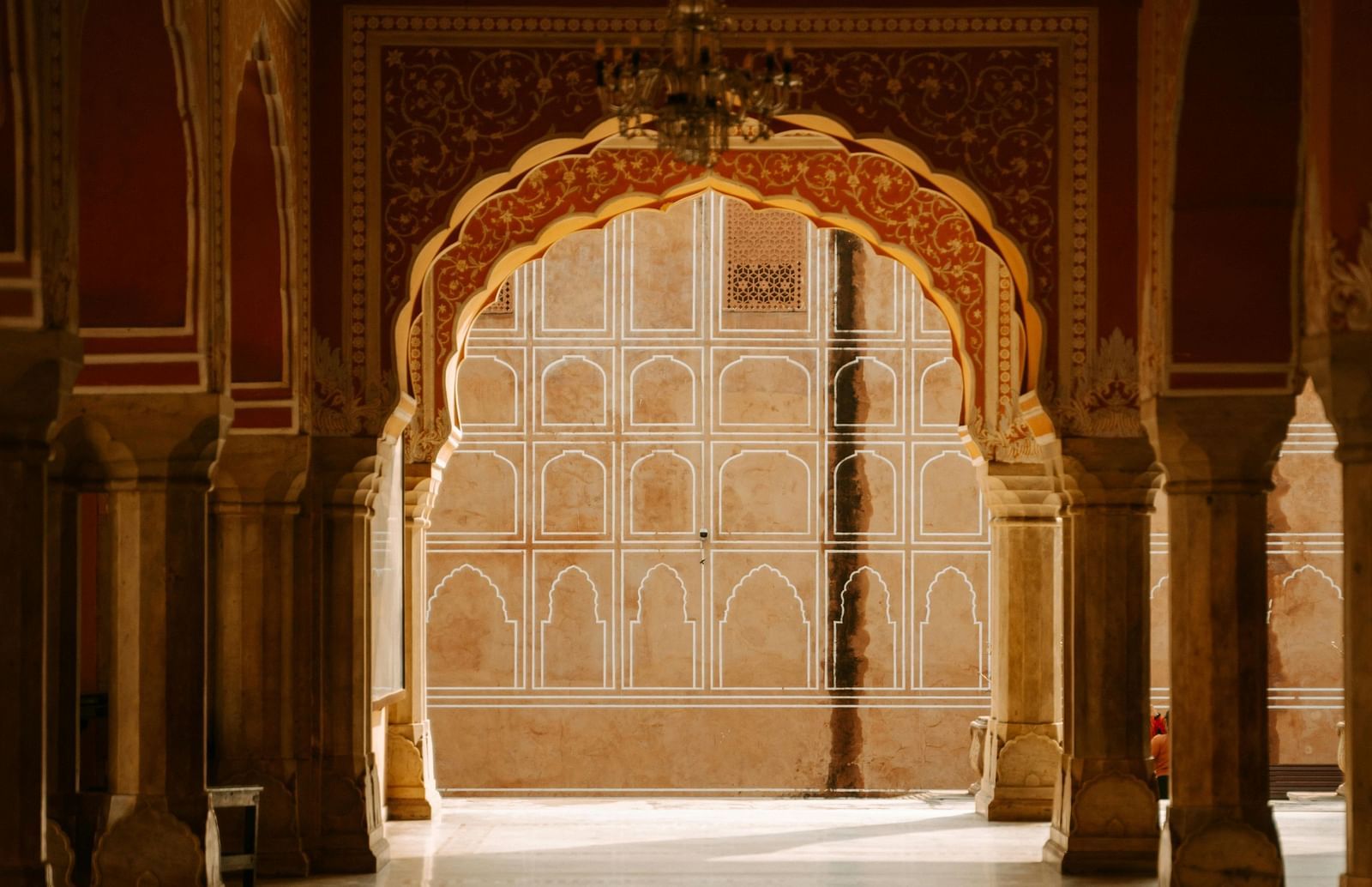 Interior corridor of a palace or heritage structure with arched doorways and patterned flooring