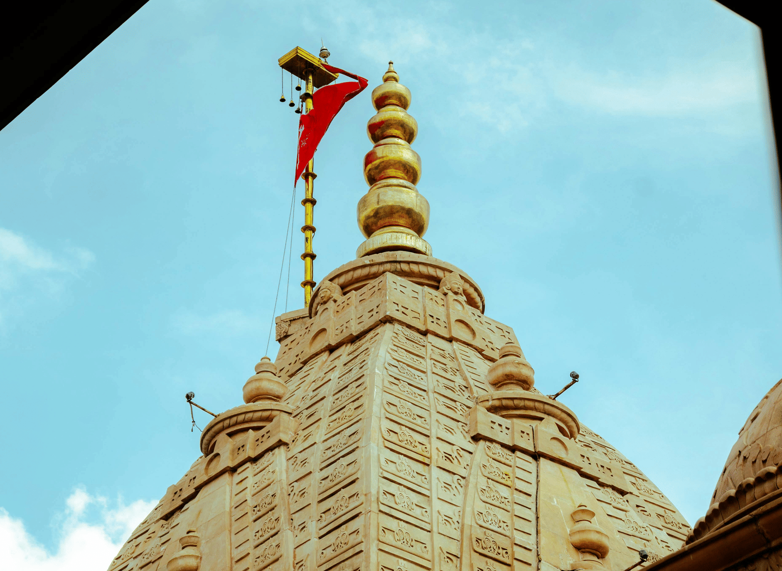 A close-up shot of the temple crown with a red-coloured flag hoisted on the top.