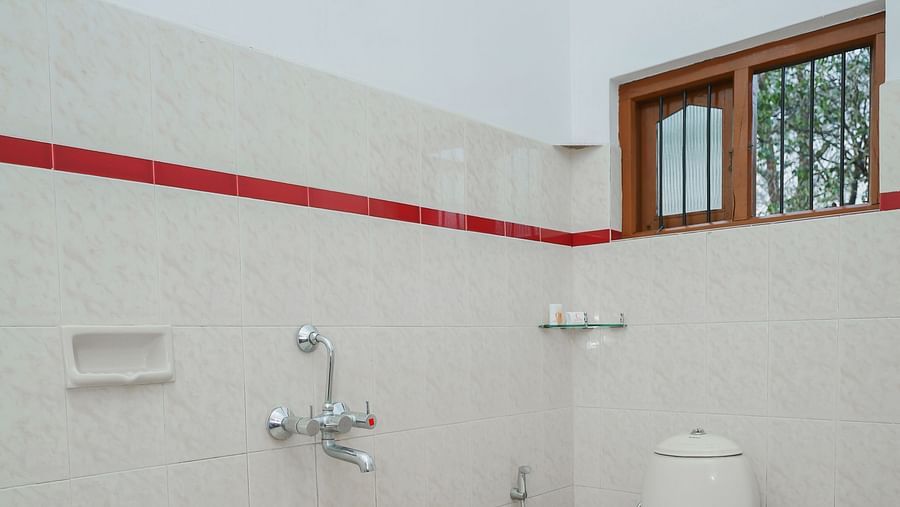 Overview of the bathroom with white tiles in one of the rooms - Capitol Village Resort, Madikeri