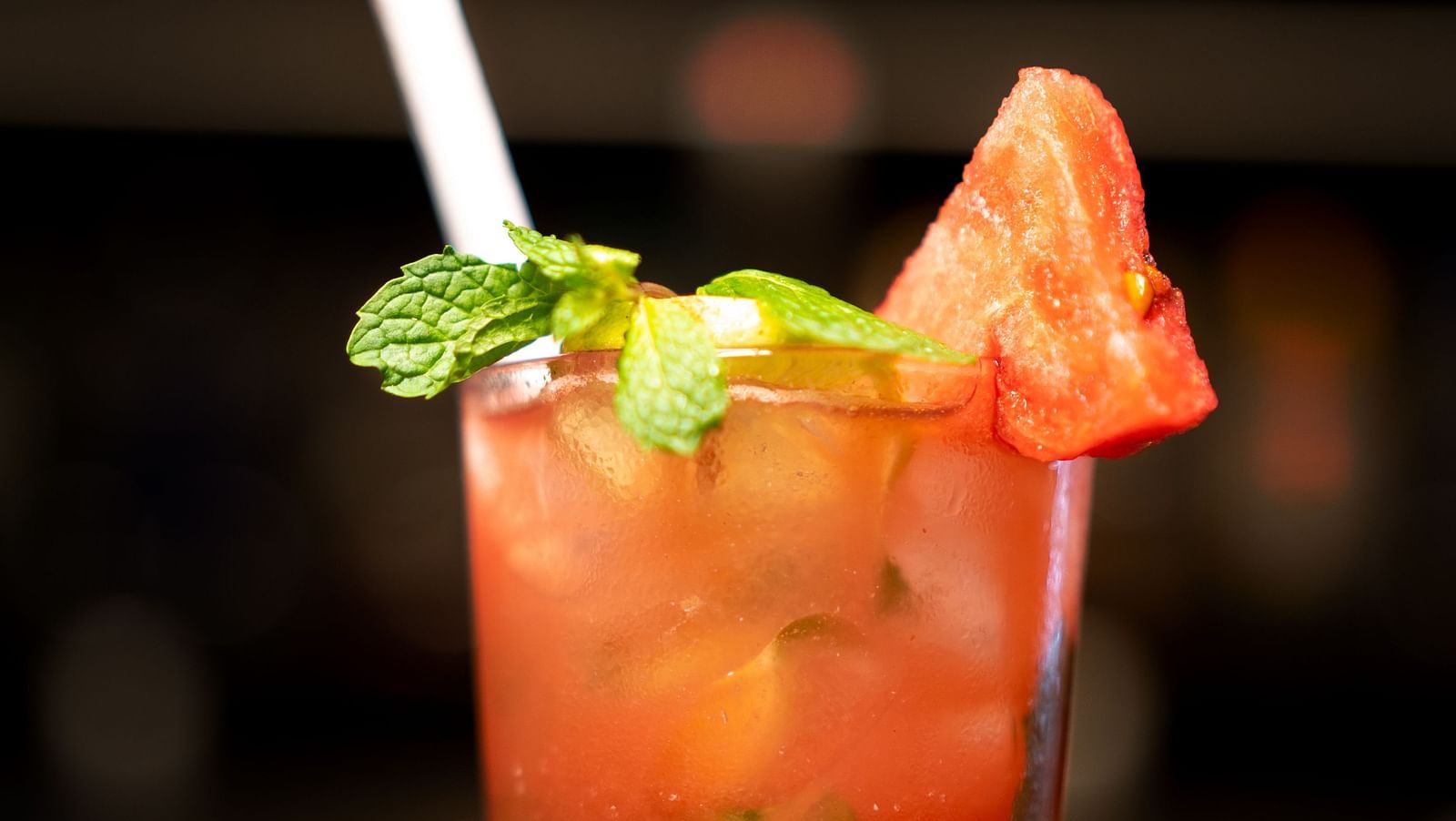 A close-up of a strawberry cocktail garnished with mint on a bed of crushed ice - TGI Ameya Grand, Goa