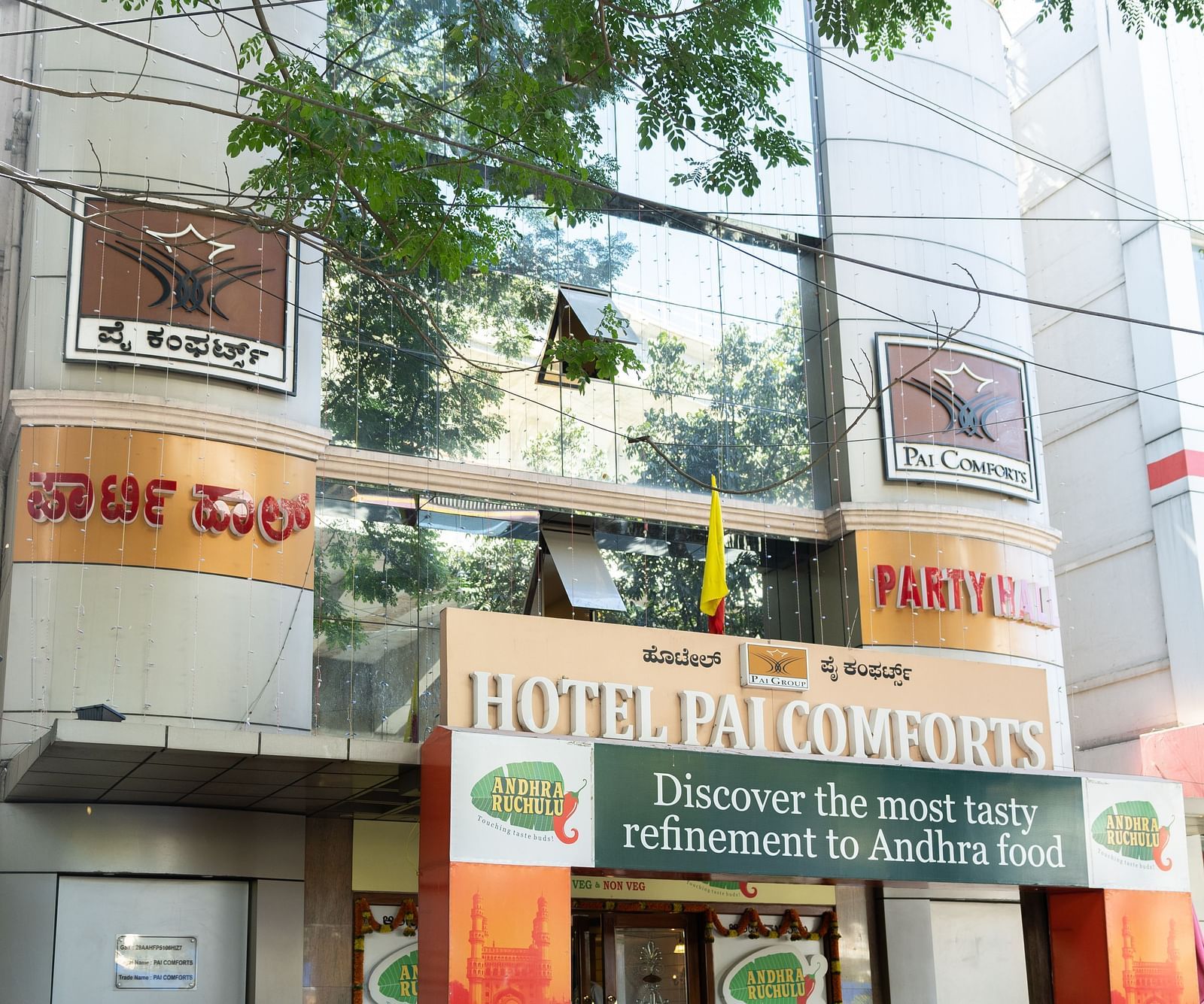 facade image of Hotel Pai Comforts, JP Nagar with tree branches above