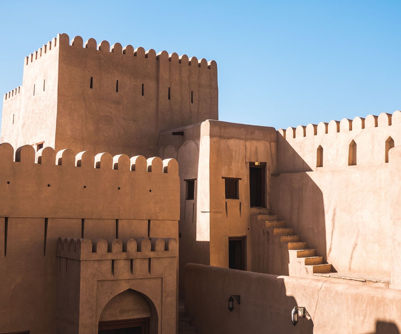 A fort with doors and steps leading to different rooms inside and the blue sky in the background