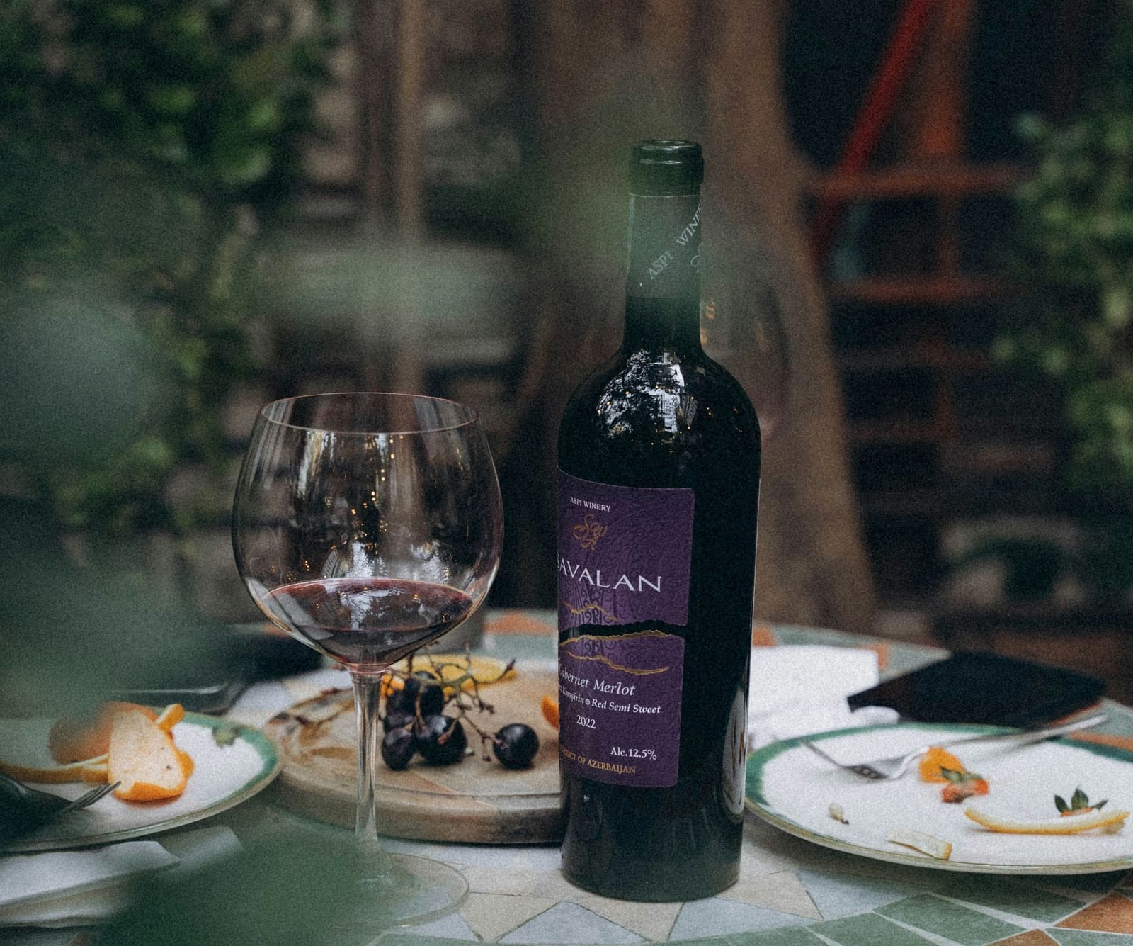 An overview of a table with a bottle of wine and food kept in the plates