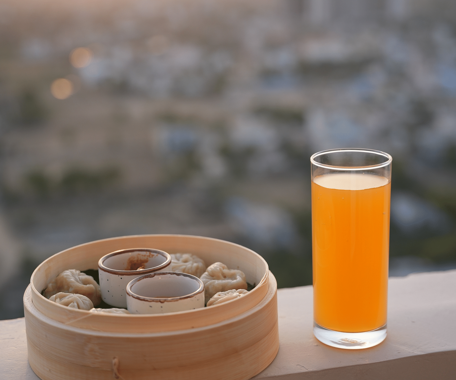 A pan-asian dish kept on the ledge with a glass of juice - Rhythm Gurugram