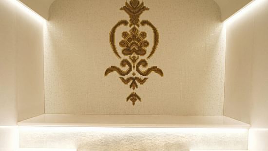 An image of a steam room with tiled interior and warm lighting