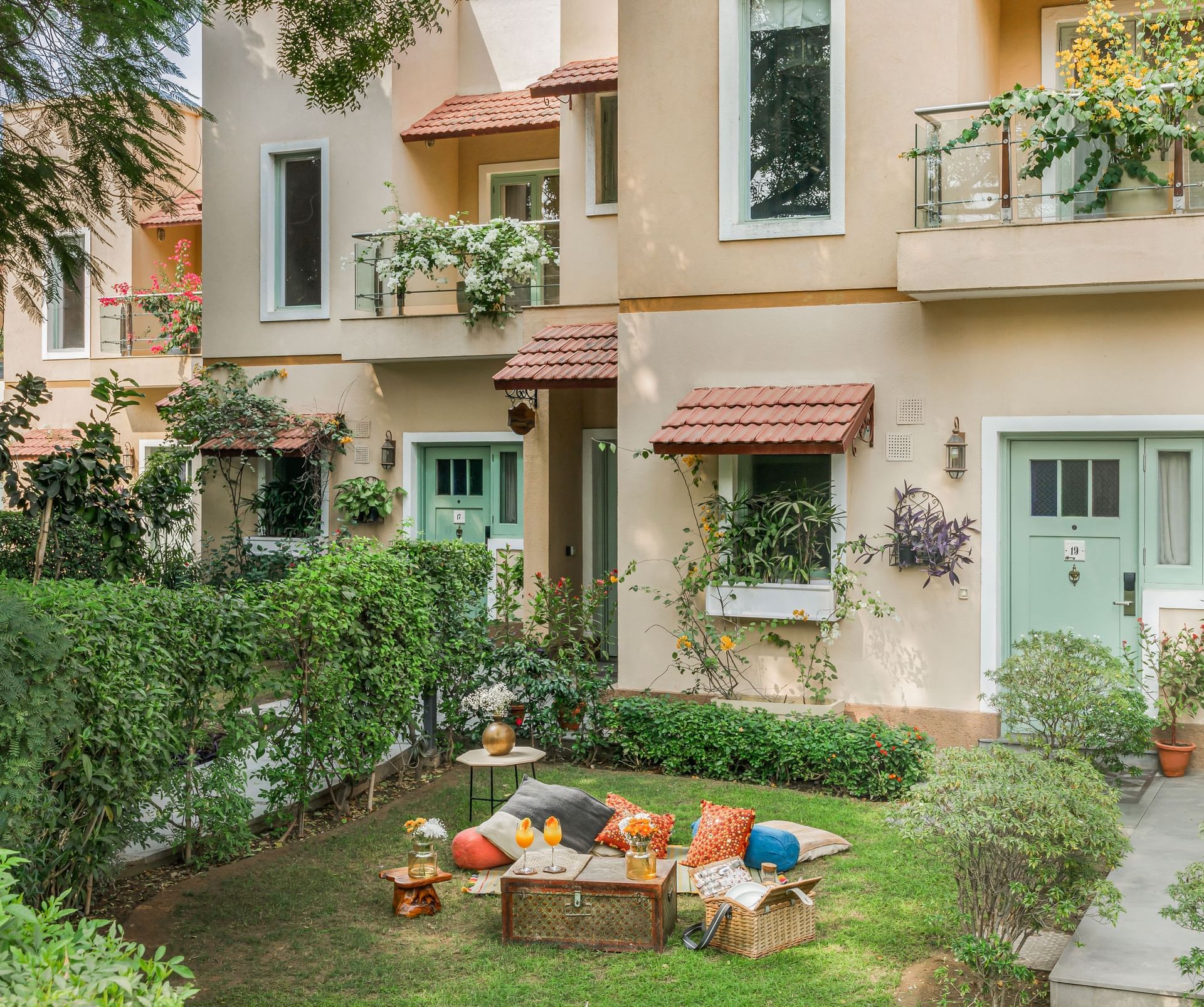 Exterior view of Karma Chalets with garden seating and green surroundings.