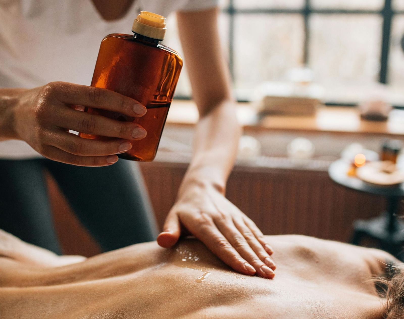A woman getting a back massage by a massasue. 