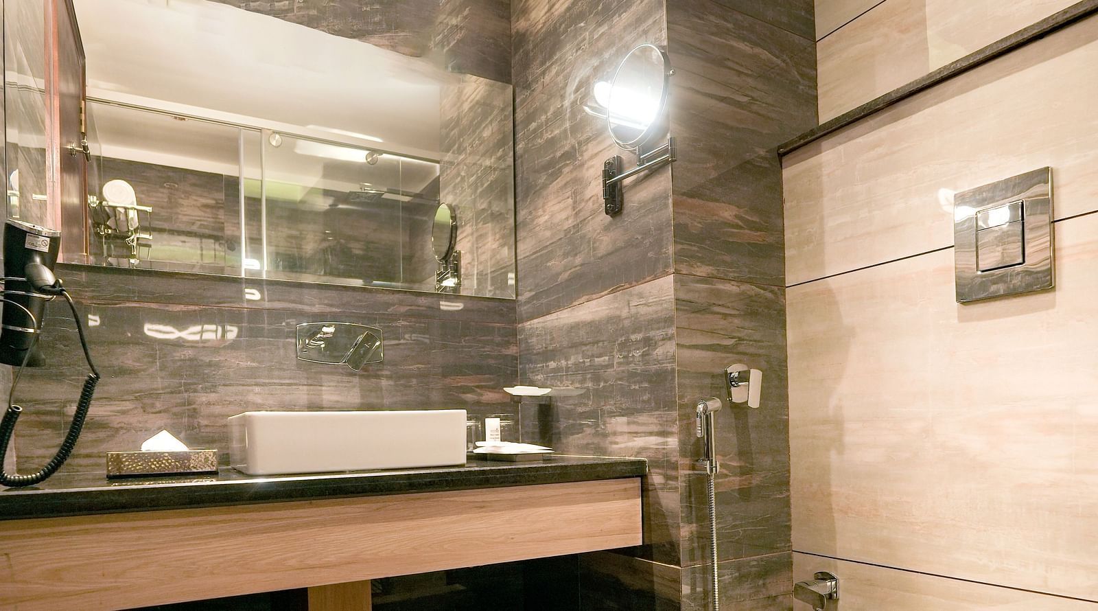 A washroom in our hotel room that features a large sink, a commode, and a wall-mounted sink - NAMAMI BY ZENQ BANKHANDI
