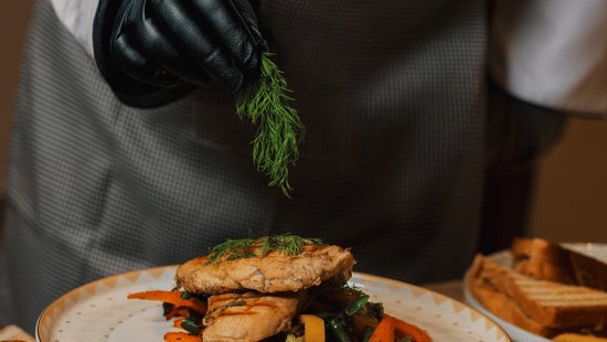 Chef plating gourmet dishes, wearing gloves - Lamrin Morjim Goa