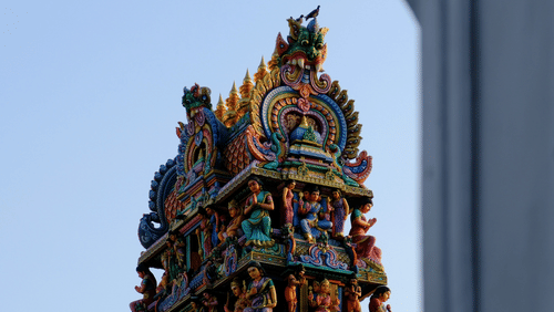 Facade view of Mariamman Temple with many other figurines of people and deities on the gopuram.