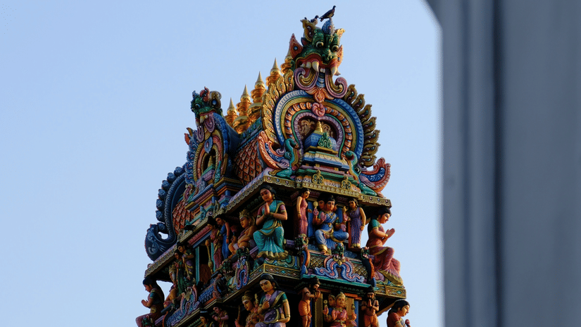 Facade view of Mariamman Temple with many other figurines of people and deities on the gopuram.