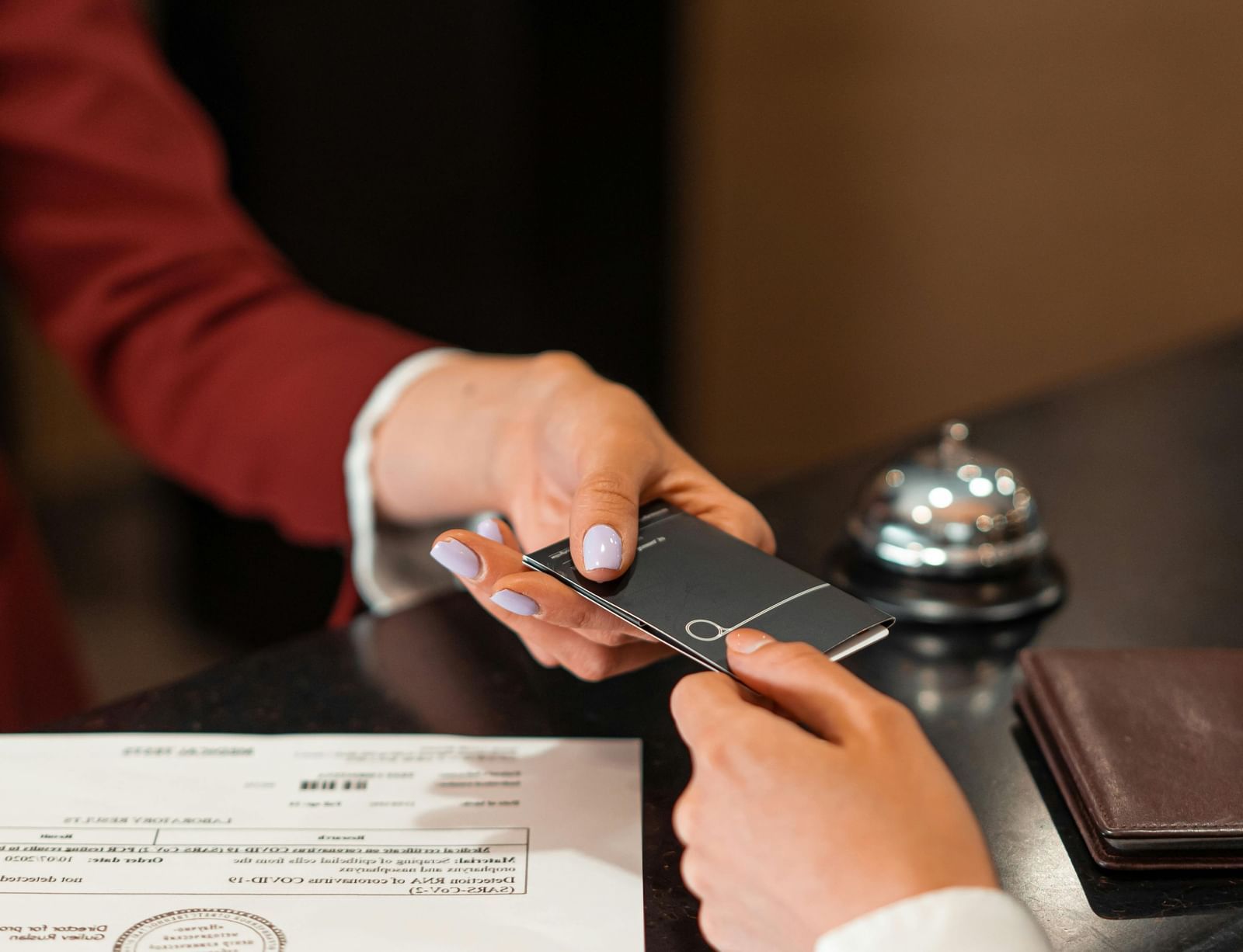  A hotel receptionist handing a room key card to a guest during check-in.