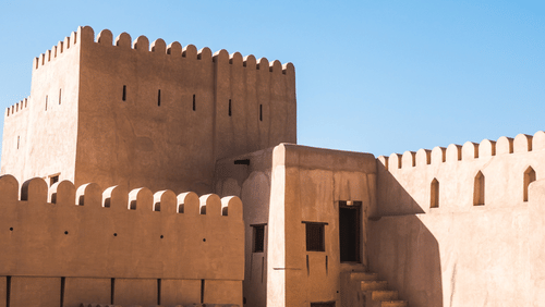 A fort with doors and steps leading to different rooms inside and the blue sky in the background