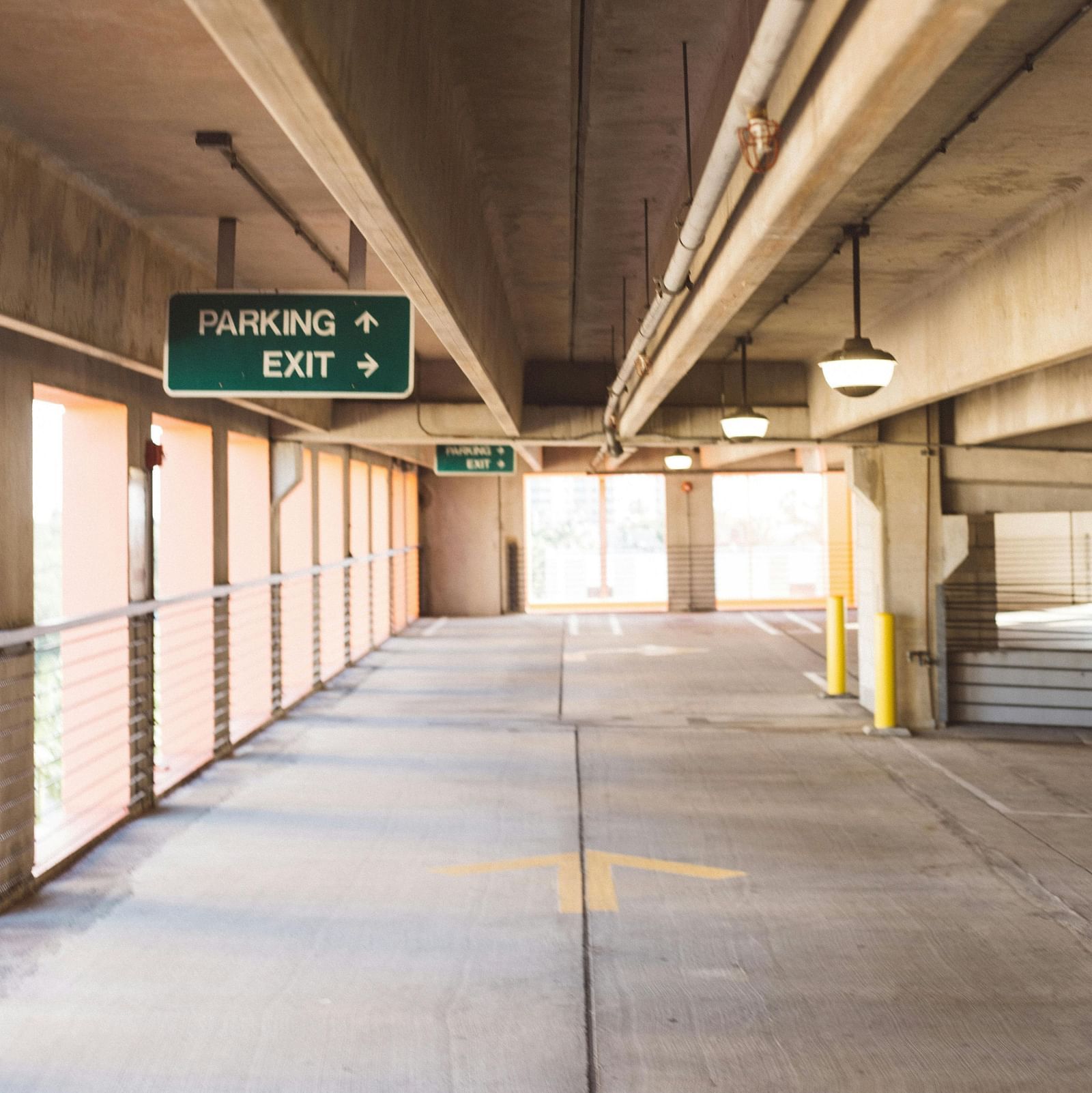 image of an empty parking space on a bright day with guiding arrows printed on the floor
