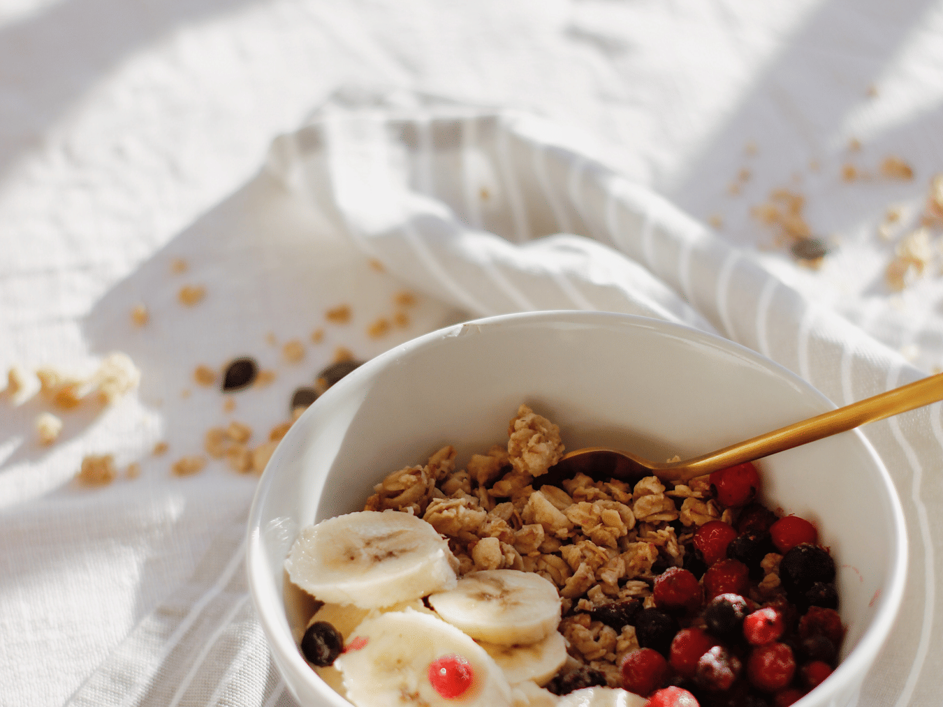 Home2 Suites & Service Apartments, Mumbai Airport - a bowl of granola topped with banana and mixed berries