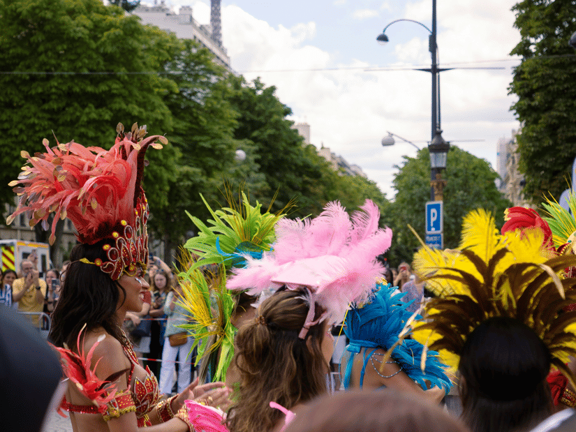 A crowd of people wearing costumes walking down the street under a bright sky
