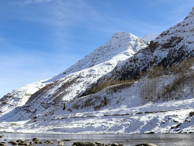 A river flowing beside snowy mountain.