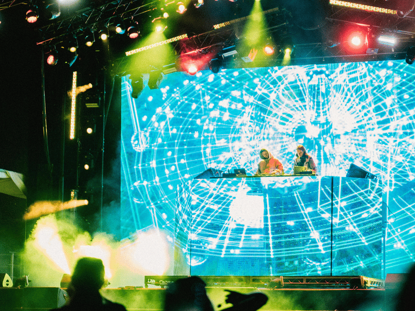 Crowd enjoying a live concert with vibrant LED visuals, stage lights, and energetic festival atmosphere