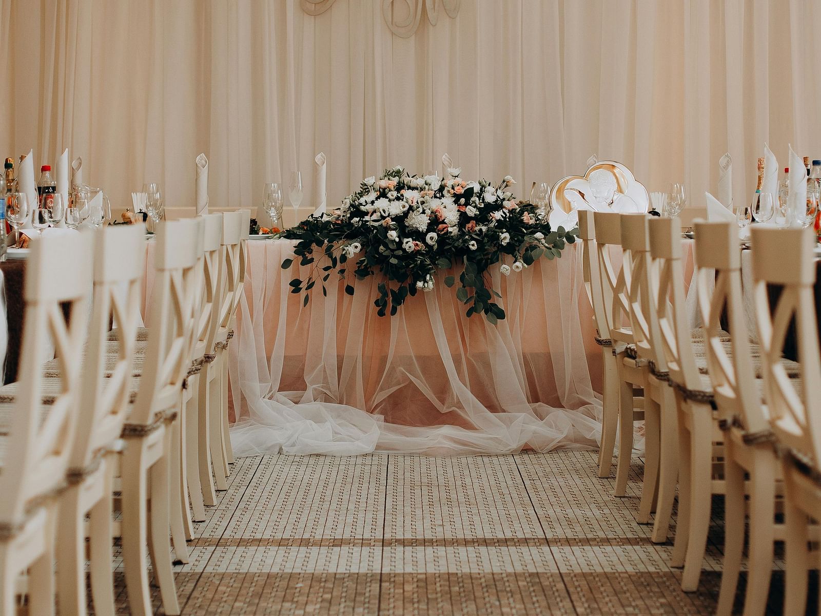 A beautifully decorated aisle leads to a stage in a wedding or event space at Lords Plaza Surat.