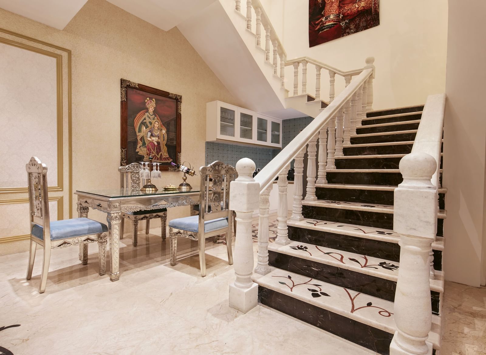 An elegant staircase and hallway with contemporary paintings and sleek white marble flooring - Kaldan Samudhra