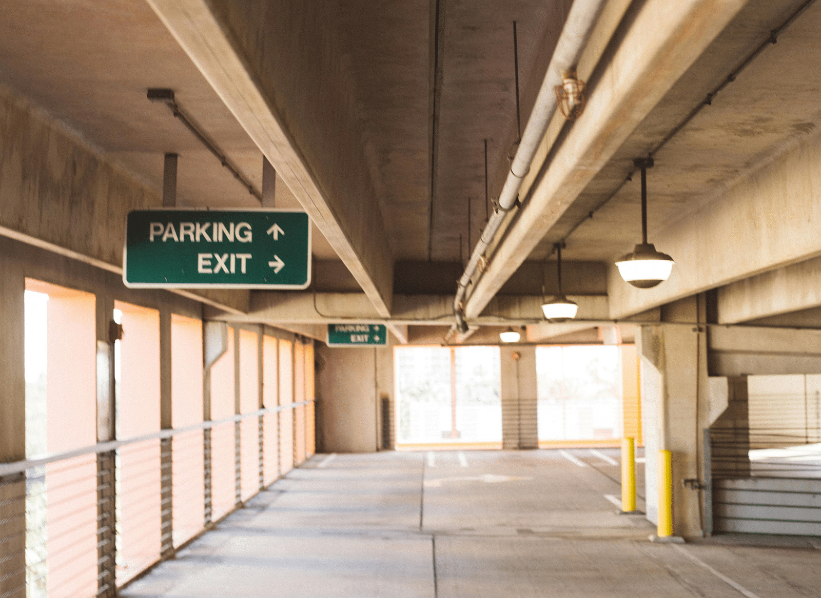  A spacious corridor with bright, modern lighting and clear signage, leading to different parts of the building. The design is clean and functional.