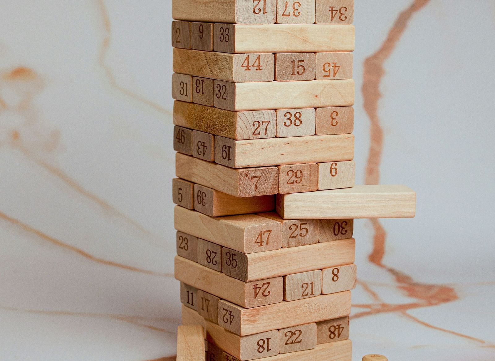 Wooden Jenga blocks stacked on a surface, partially disassembled mid-game.